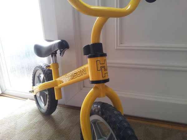 A child's balance bike custom painted yellow