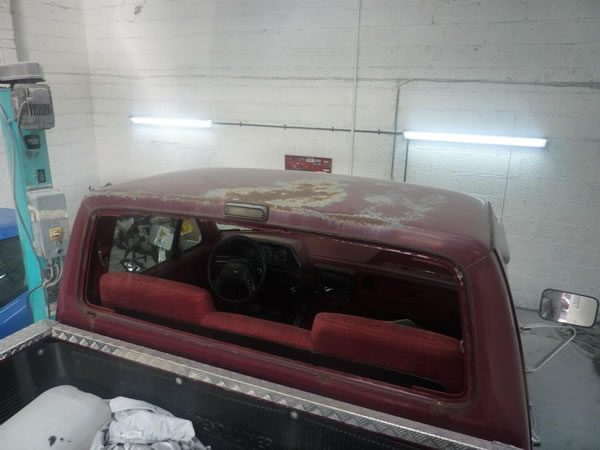 The back of the pickup's cab in the booth, under the strip lights